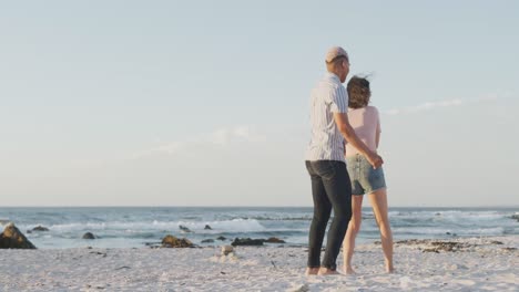 Happy-biracial-couple-dancing-together-at-beach,-in-slow-motion,-with-copy-space