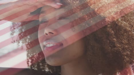 Animation-of-flag-of-usa-over-african-american-woman-on-beach