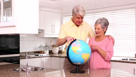 Senior-couple-looking-at-globe-together