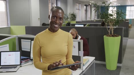 Retrato-De-Una-Sonriente-Empresaria-Afroamericana-Usando-Una-Tableta-En-La-Oficina,-Cámara-Lenta
