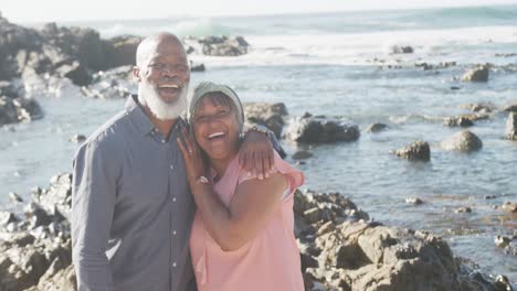 Portrait-of-happy-senior-african-american-couple-embracing-at-beach,-copy-space,-slow-motion
