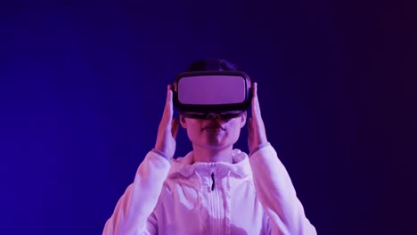 Asiatische-Frau-Mit-VR-Headset-Auf-Blauem-Hintergrund,-Kopierraum,-Zeitlupe