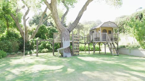 Jardín-Verde-Con-Un-Gran-árbol-Y-Un-Parque-Infantil-De-Madera-En-Un-Día-Soleado