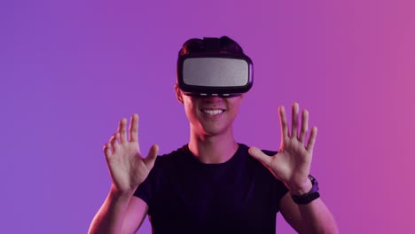 Happy-asian-man-using-vr-headset-and-touching-virtual-screen-on-purple-background,-slow-motion