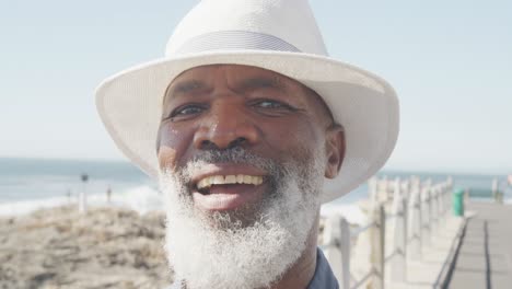 Portrait-of-senior-african-american-man-on-promenade-by-the-sea,-slow-motion