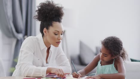 Afroamerikanische-Mutter-Und-Tochter-Sitzen-Am-Tisch-Und-Machen-Gemeinsam-Hausaufgaben,-Zeitlupe