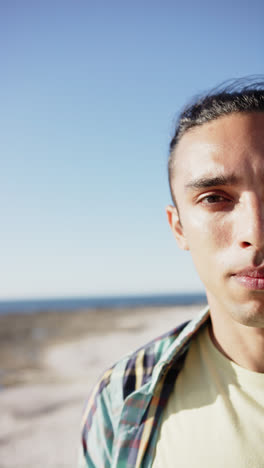 Vertical-video-of-happy-biracial-man-at-promenade-by-the-sea,-slow-motion