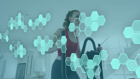 Animation-of-data-processing-over-caucasian-woman-exercising,-using-stationary-bike-at-home