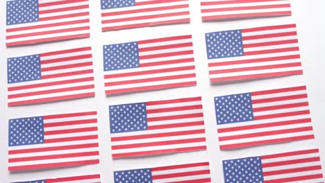 Multiple-national-flags-of-usa-lying-in-row-on-white-background