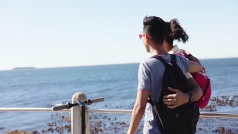 Happy-diverse-gay-male-couple-embracing-at-promenade-by-the-sea,-slow-motion