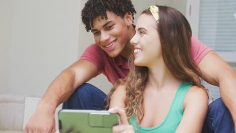 Happy-biracial-couple-spending-time-at-home-and-taking-selfie-with-smartphone