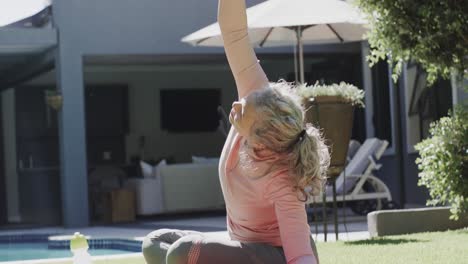 Happy-senior-caucasian-woman-doing-yoga,-stretching-in-garden,-slow-motion