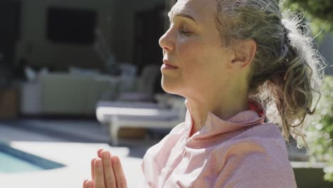Glückliche-ältere-Kaukasische-Frau,-Die-Yoga-Macht,-Im-Garten-Meditiert,-Zeitlupe