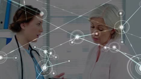 Animation-of-network-of-connections-over-caucasian-female-doctor-with-female-patient