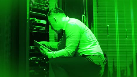Animation-of-green-shade-over-caucasian-male-worker-in-server-room