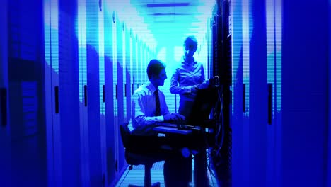 Animation-of-blue-shade-over-caucasian-workers-in-server-room