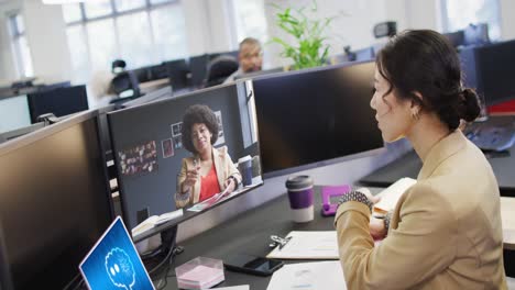 Diversas-Mujeres-Empresarias-En-Videollamadas-Por-Computadora-Con-Procesamiento-De-Datos-En-Una-Computadora-Portátil-En-La-Oficina