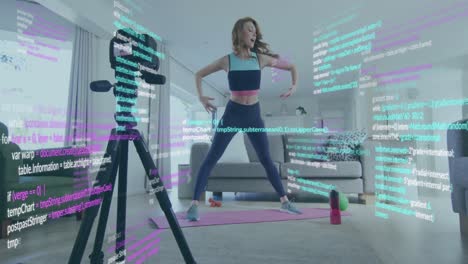 Animation-of-computer-language-over-caucasian-woman-recording-stretching-on-video-recorder-at-home