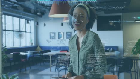 Animation-of-data-processing-over-african-american-woman-using-digital-tablet-and-smiling-at-office