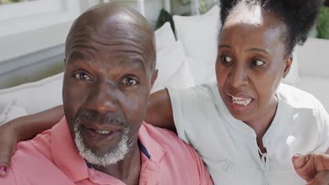 Portrait-of-happy-senior-african-american-couple-having-video-call-in-slow-motion