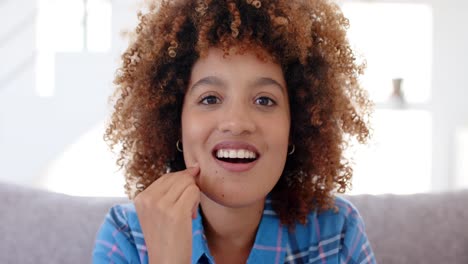 Portrait-of-happy-biracial-woman-having-video-call-in-living-room-in-slow-motion