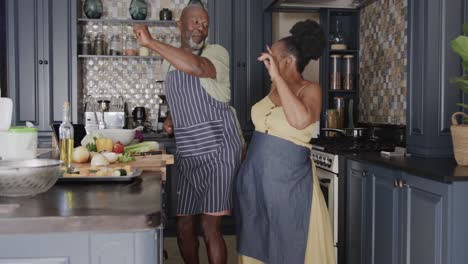Happy-senior-african-american-couple-dancing-in-ktichen-in-slow-motion
