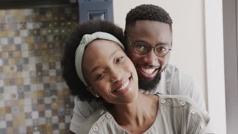 Portrait-of-happy-african-american-couple-embracing-in-ktichen-in-slow-motion
