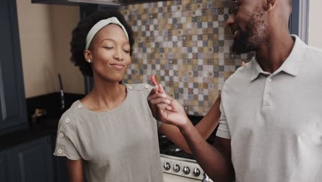 Fröhliches-Afroamerikanisches-Paar,-Das-In-Zeitlupe-In-Der-Küche-Probiert