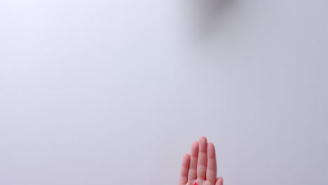 Hands-of-caucasian-people-holding-blood-drop-on-white-background-with-copy-space,-slow-motion