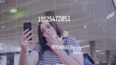Animation-of-changing-numbers-over-caucasian-woman-having-a-video-call-on-smartphone-on-the-street