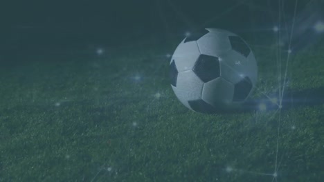 Animation-of-network-of-connections-over-football-player-with-football-on-pitch