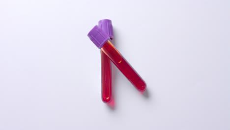 Close-up-of-blood-samples-on-white-background-with-copy-space,-slow-motion