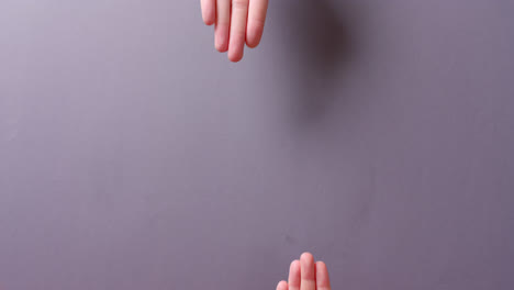 Hands-of-caucasian-people-holding-blood-drop-on-grey-background-with-copy-space,-slow-motion