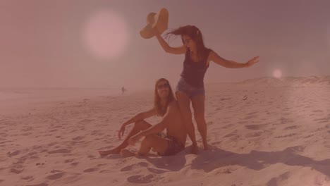 Animation-of-light-spots-over-caucasian-women-playing-at-beach-and-smiling