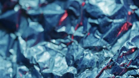 Close-up-of-blue-crumpled-pieces-of-plastic-material-in-slow-motion
