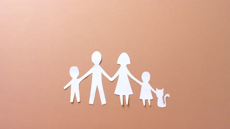 Close-up-of-family-with-cat-made-of-white-paper-on-beige-background-with-copy-space