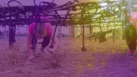 Animation-of-light-spots-over-diverse-women-at-obstacle-course-crawling
