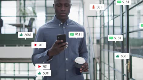 Animation-of-social-media-icons-on-african-american-man-drinking-coffee-using-smartphone-at-office
