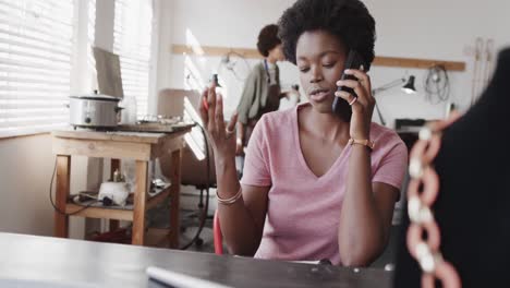 Ocupada-Trabajadora-Afroamericana-Hablando-Por-Teléfono-Inteligente-En-Un-Estudio-De-Joyería-En-Cámara-Lenta