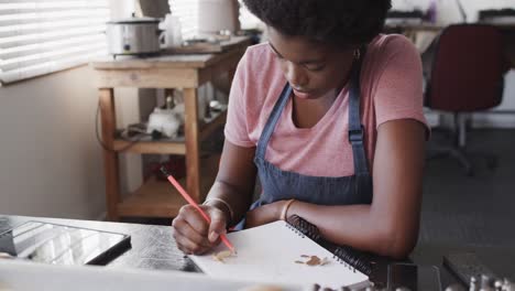 Vielbeschäftigte-Afroamerikanische-Arbeiterin-Zeichnet-Schmuckdesign-Im-Schmuckstudio-In-Zeitlupe