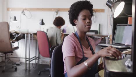 Busy-african-american-female-worker-holding-ring-in-jewellery-studio-in-slow-motion