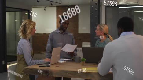 Animation-of-changing-numbers-floating-over-diverse-colleagues-discussing-together-at-office