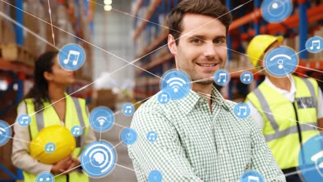 Animation-of-network-of-digital-icons-against-caucasian-male-supervisor-smiling-at-warehouse