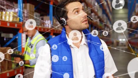 Animation-of-network-of-profiles-over-caucasian-male-supervisor-using-digital-tablet-at-warehouse