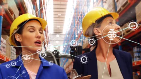 Animation-of-network-of-connections-with-people-icons-over-diverse-women-working-in-warehouse