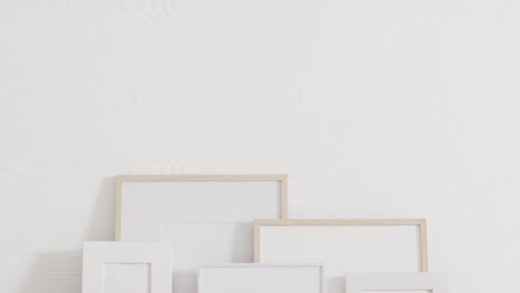 Wooden-and-white-frames-with-copy-space-on-white-background-and-white-wall