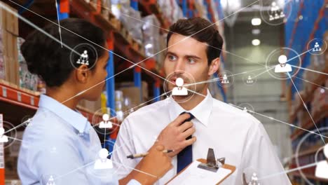 Animation-of-network-of-connections-with-people-icons-over-diverse-people-working-in-warehouse