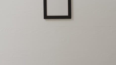 Wooden-frame-with-copy-space-hanging-on-white-wall