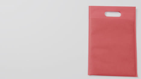 Nahaufnahme-Einer-Roten-Tasche-Auf-Weißem-Hintergrund,-Kopierraum,-Zeitlupe