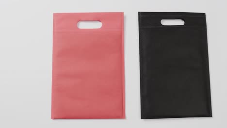 Close-up-of-red-and-black-bags-on-white-background,-copy-space,-slow-motion
